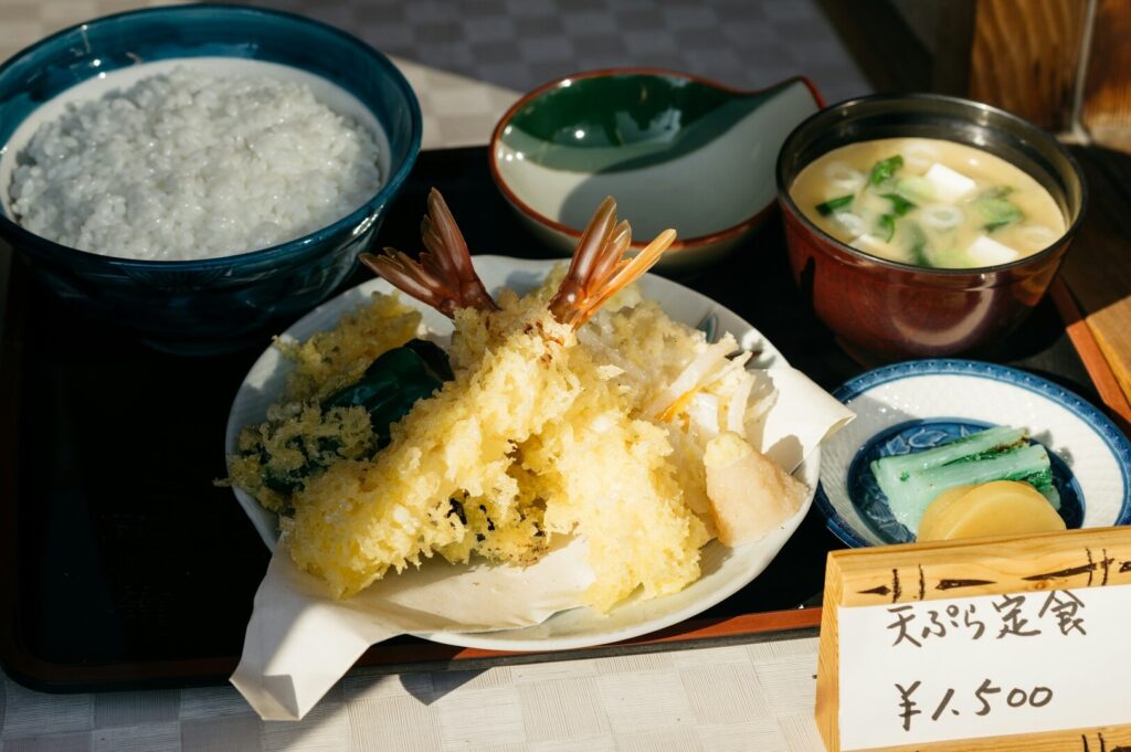 A beautifully arranged tray with rice, fish, and assorted Japanese dishes, highlighting the elegance of Japanese cuisine.
