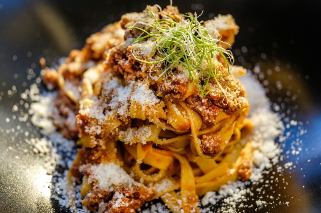 A serving of pasta featuring meat and cheese, representing a traditional Italian regional dish.