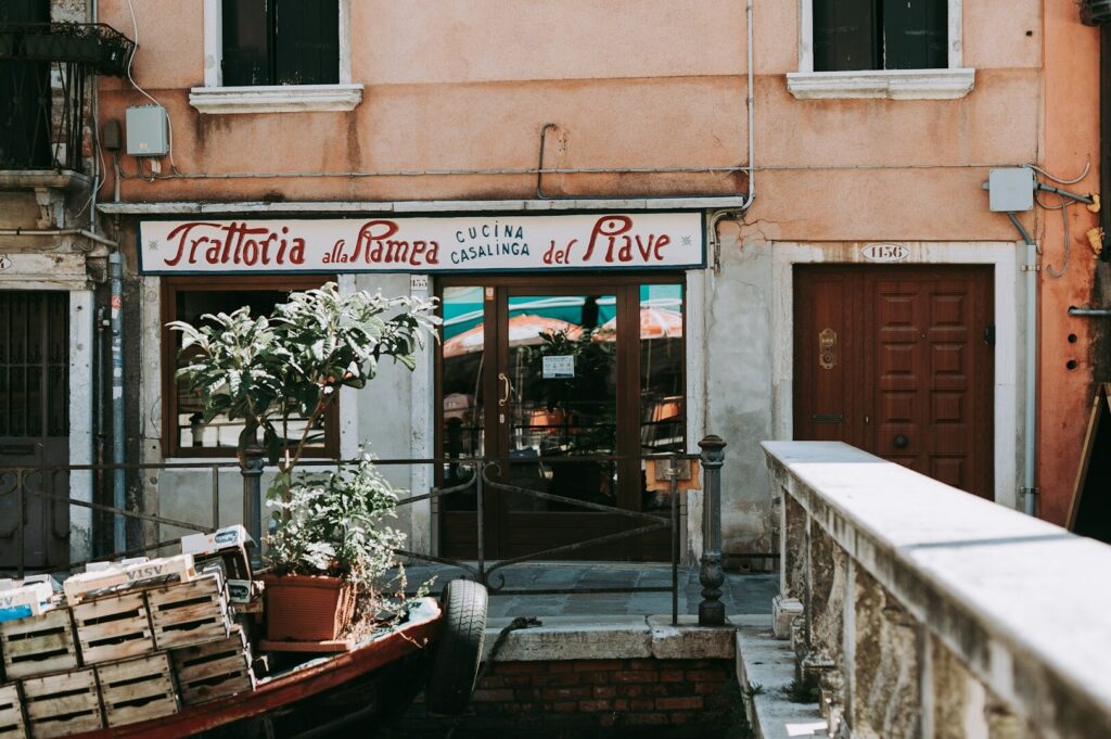 A calm and serene Italian restaurant hidden by the gentle touch of the shadows made by Italy's lovely day of sunshine.