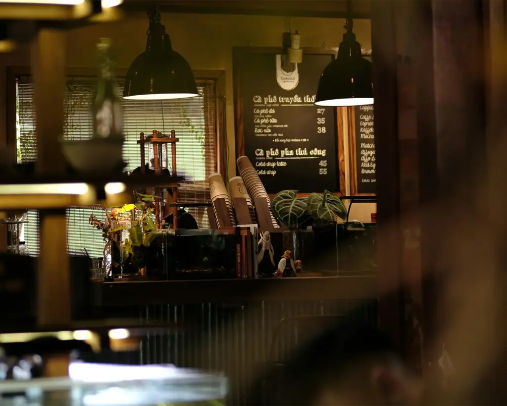 A warm and inviting café interior with soft lighting, comfortable seating, and intimate corners that create a relaxed, homely atmosphere for guests to unwind.