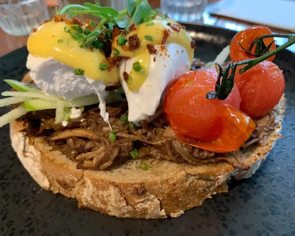 A hearty plate of fluffy eggs served generously alongside thick slices of toasted sourdough bread, presented simply yet appetisingly.