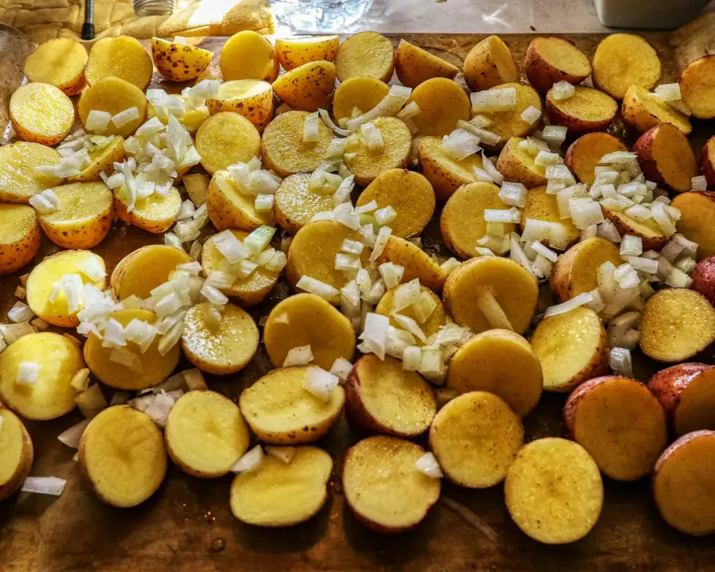 Sliced potatoes and onions gently cooking in a pan with olive oil, slowly softening as they absorb the rich flavour and aroma of the oil.