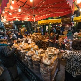 Bustling food market with artisan bread stalls and locals exploring culinary delights